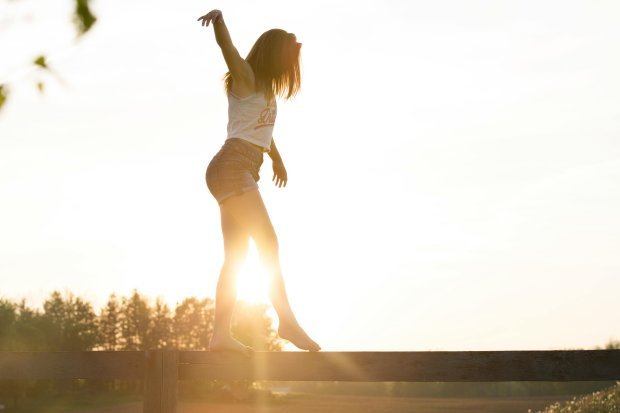 Woman balancing on a fence